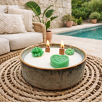 Coulée à la main en Provence, cette bougie d’extérieur anti moustique repose dans une élégante coupelle en céramique verte,  brute et minimaliste qui sublimera vos tables d'été. Ses mèches en bois naturel crépitent délicatement à l'allumage, créant une atmosphère sonore aussi relaxante que visuelle.